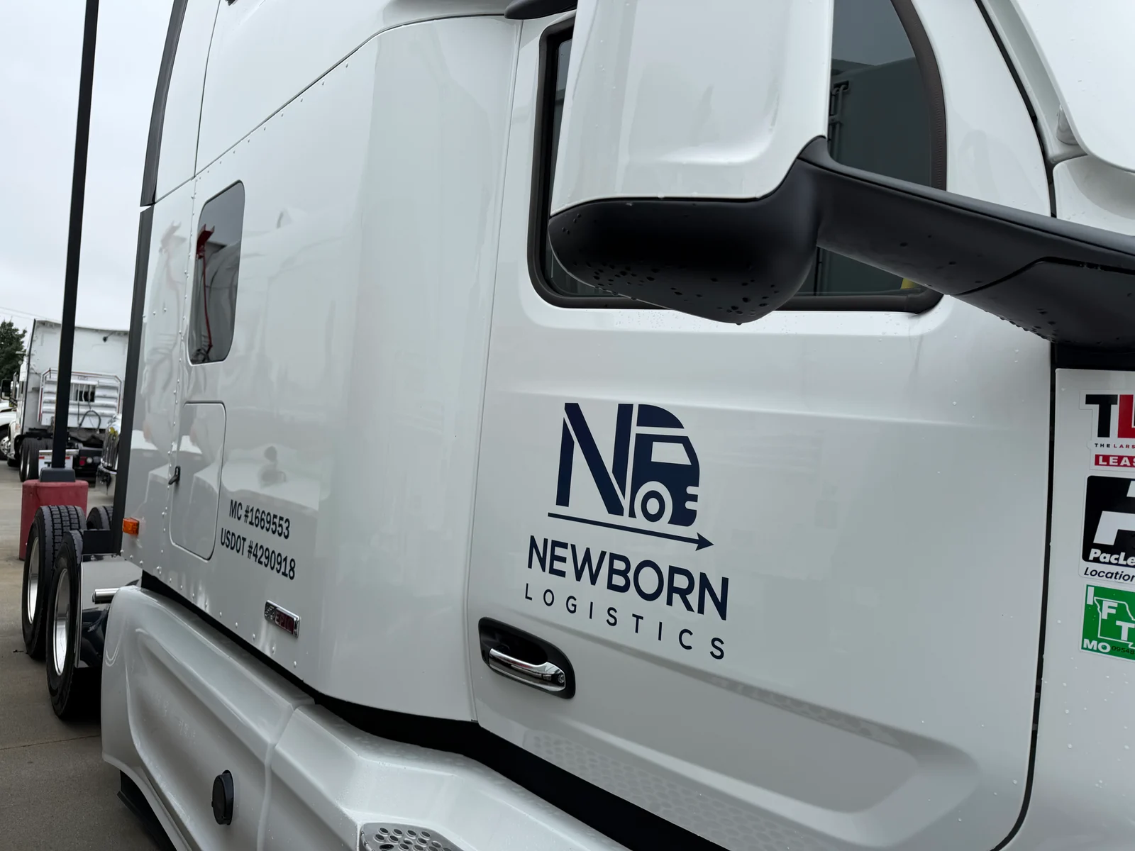 Newborn Logistics truck door displaying the company logo and MC and USDOT markings